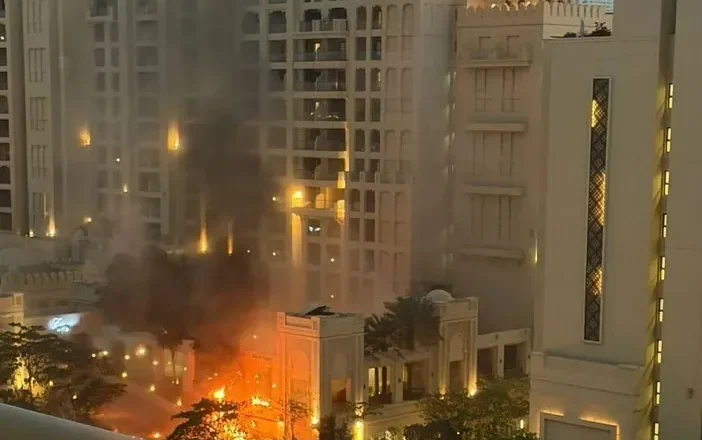 Top Dubai hotel on Palm Jumeirah in flames after being hit by missile debris from Iran blitz